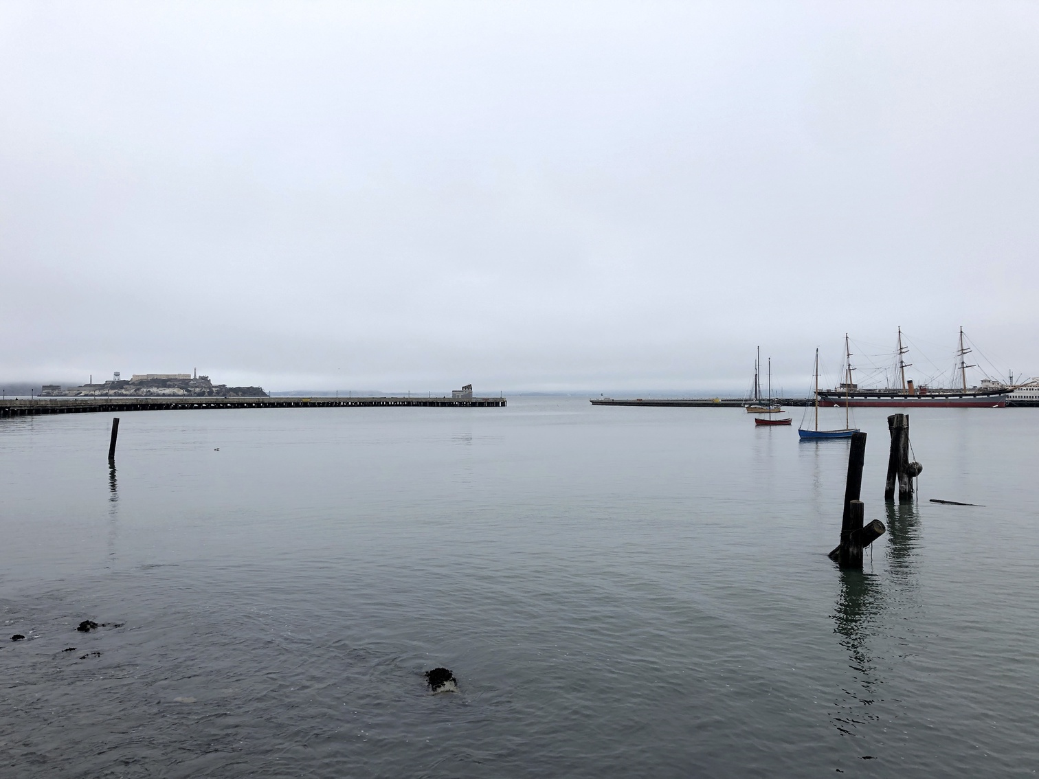 A pier in the bay with Alcatraz in the background